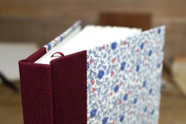 Blanko Buch zum Schreiben und Zeichnen mit blauen und rosafarbenen Streublüten, Leinenrücken beerebfarben